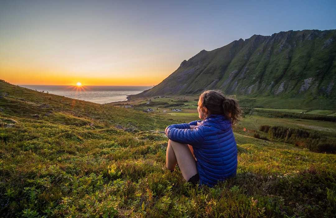 Hiker watching the midnight sun in Lofoten, Norway