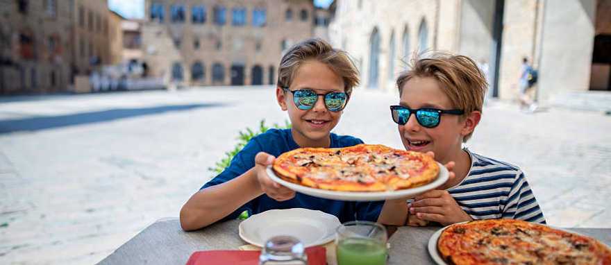 Boys enjoying a delicious Italian pizza.