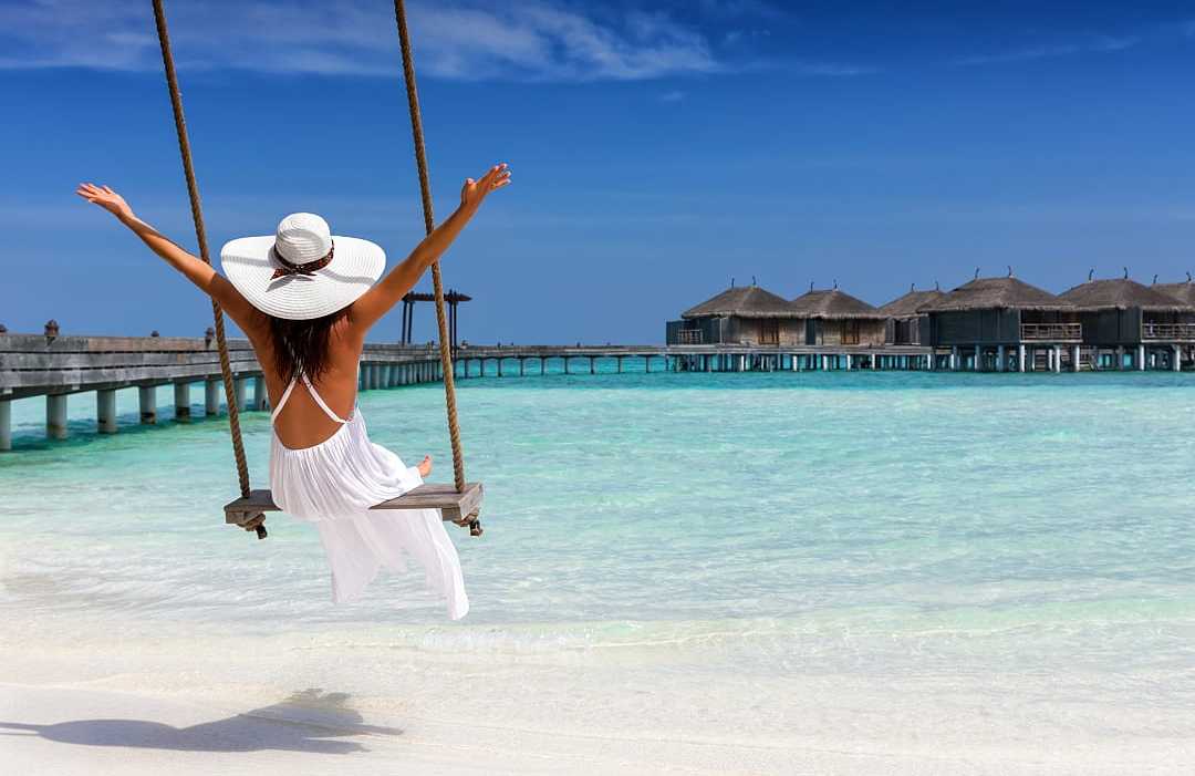 Woman enjoying a seaside swing in the Maldives Woman enjoying a seaside swing in the Maldives