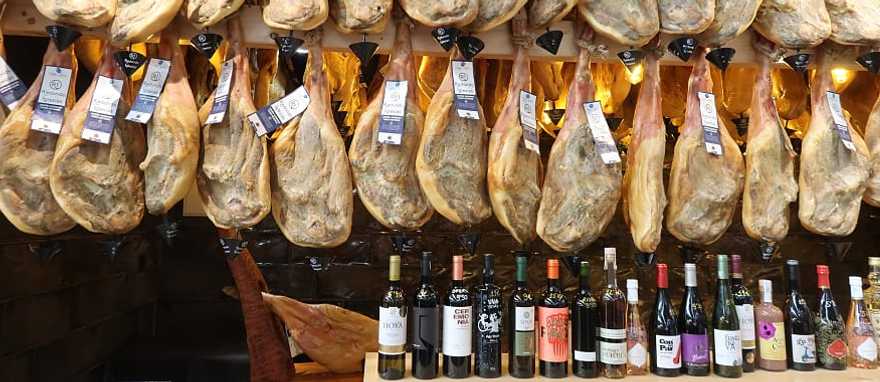 Jamon and wine for sale at a market in Spain.