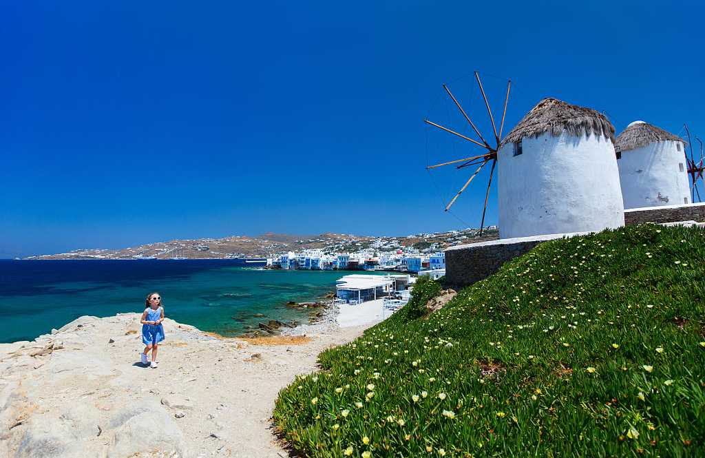 Mykonos, Greece Girl and windmills in Mykonos