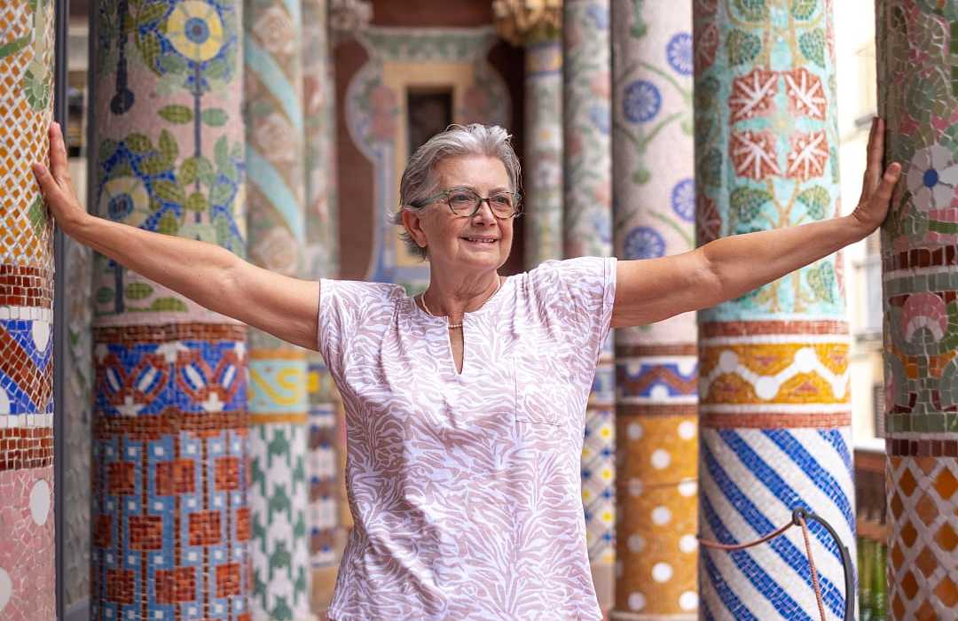Senior traveler standing between colorful pillars at Palau de la Música Catalana in Barcelona, Spain