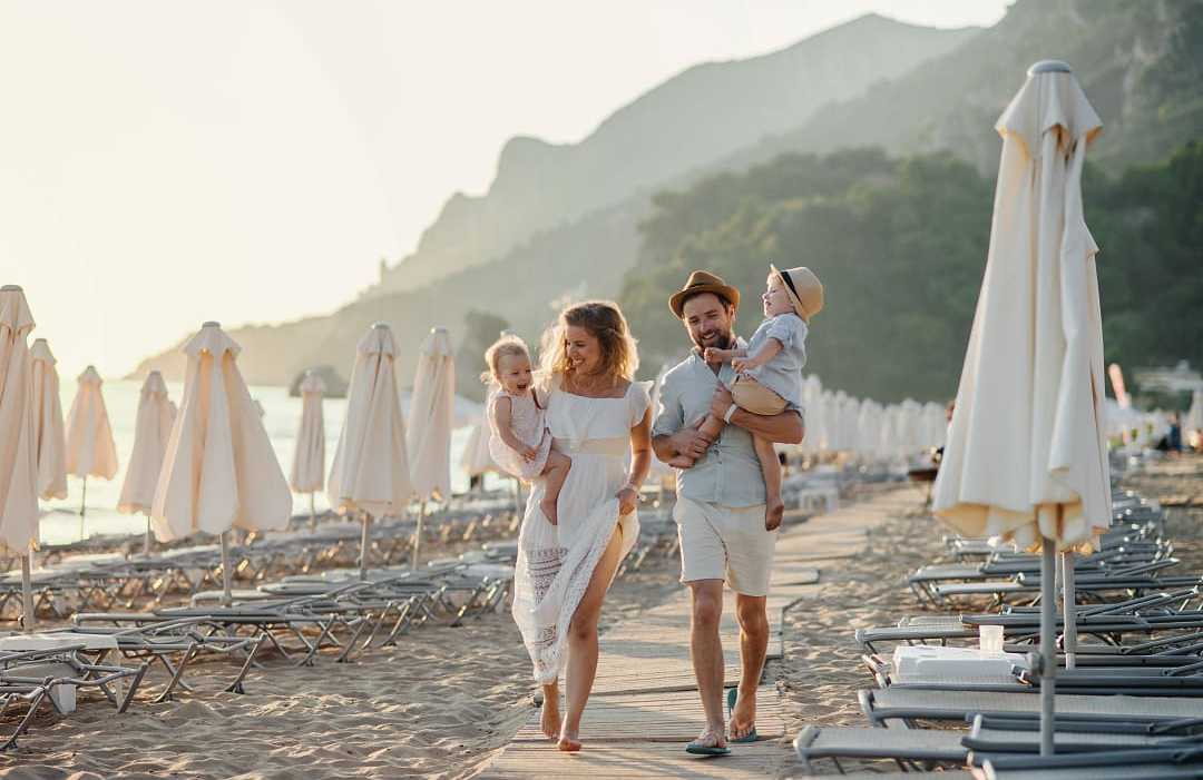 Halkidiki, Greece A young family with two toddler children walking on beach on summer vacation