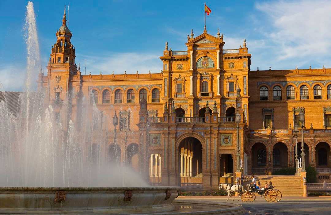 Plaza de España in Seville, Spain, featuring a grand fountain, historic architecture, and a horse-drawn carriage