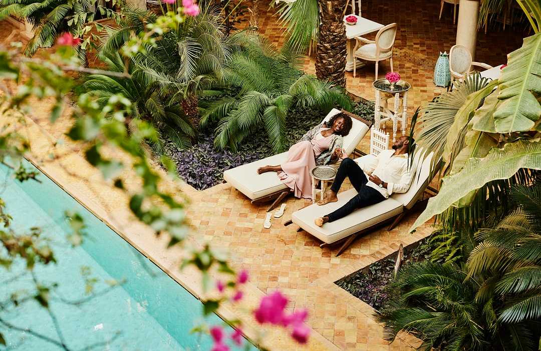 Couple at lounging by the pool at luxury riad in Marrakech, Morocco