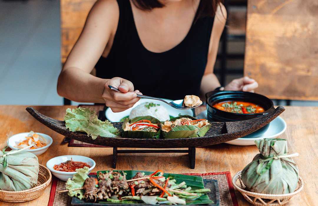 Woman enjoying mouthwatering Thai Cuisine