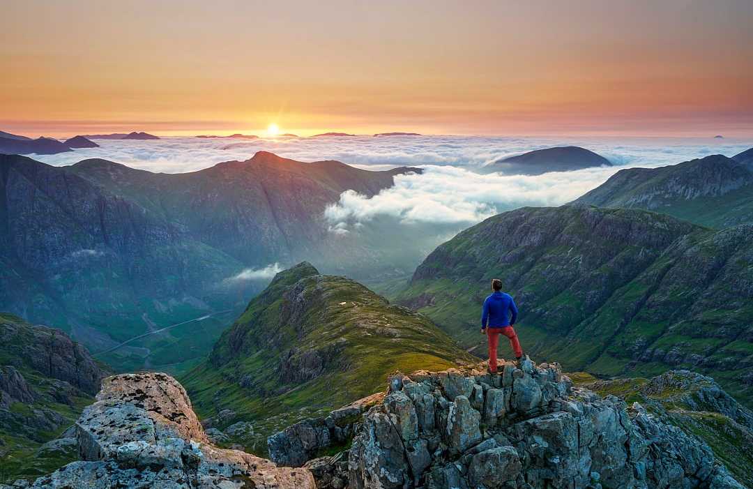 Glencoe valley in the Scottish Highlands Hiker in Glencoe, Scotland