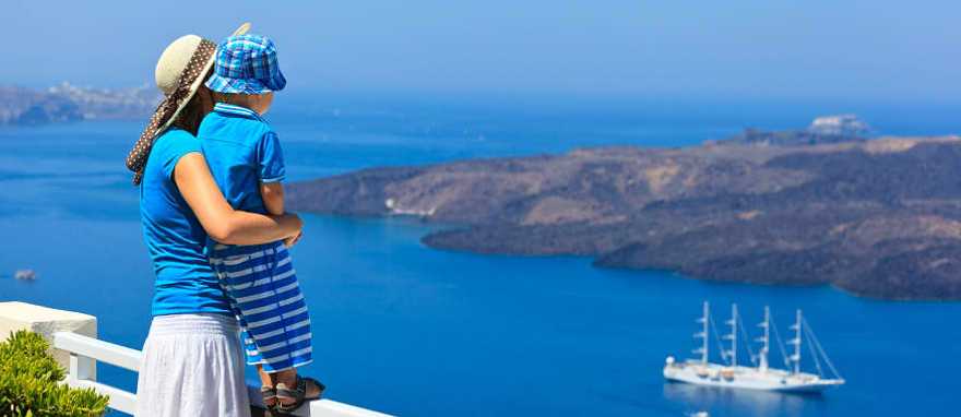 Mother and son looking out over the water in Santorini, Greece