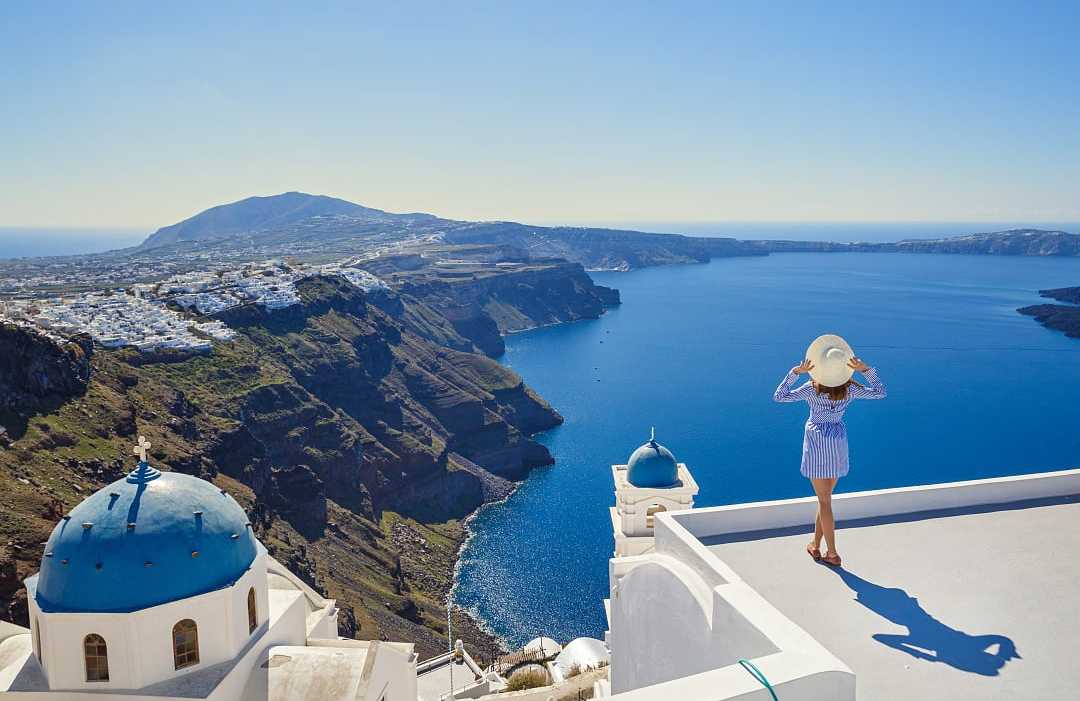 Santorini, Greece A woman admires Santorini’s breathtaking caldera and deep blue Aegean Sea.