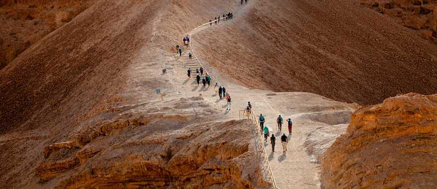 Tourist walking on Masada Fortress Rock in Israel Tourist walking on Masada Fortress Rock in Israel