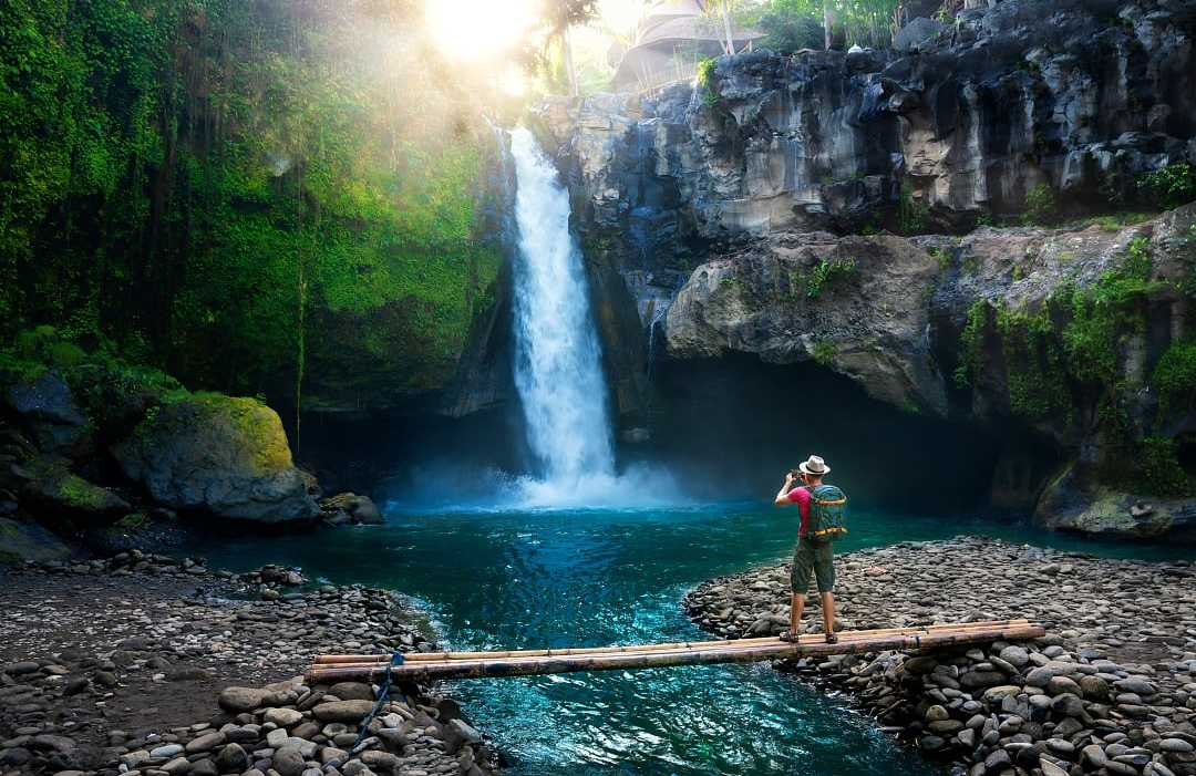 Hiker enjoying a waterfall in Bali, Indonesia 
