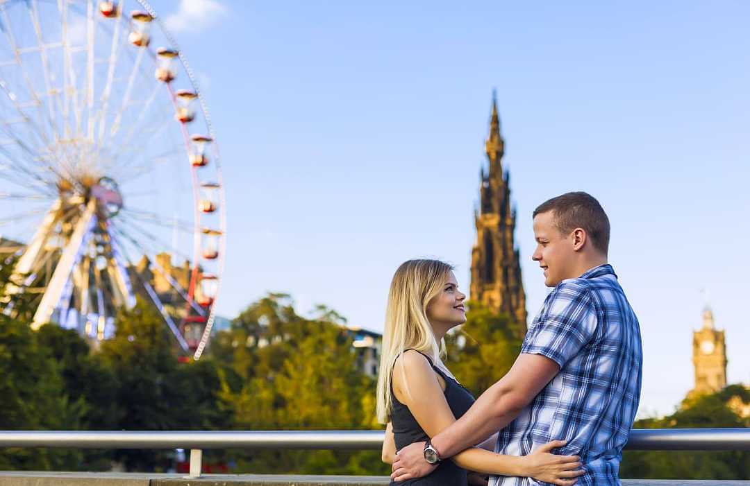 Couple with ferris wheel and Scott Monument in the background