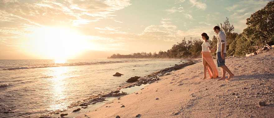 Honeymoon couple on the beach in Moorea, Tahiti.  Photo courtesy Tahiti Tourisme/Hélène Havard