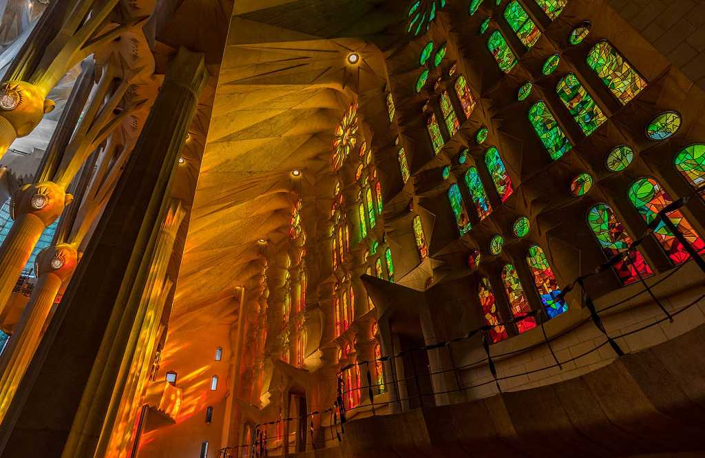 Afternoon light streaming through the stained glass windows of La Sagrada Familia in Barcelona, Spain