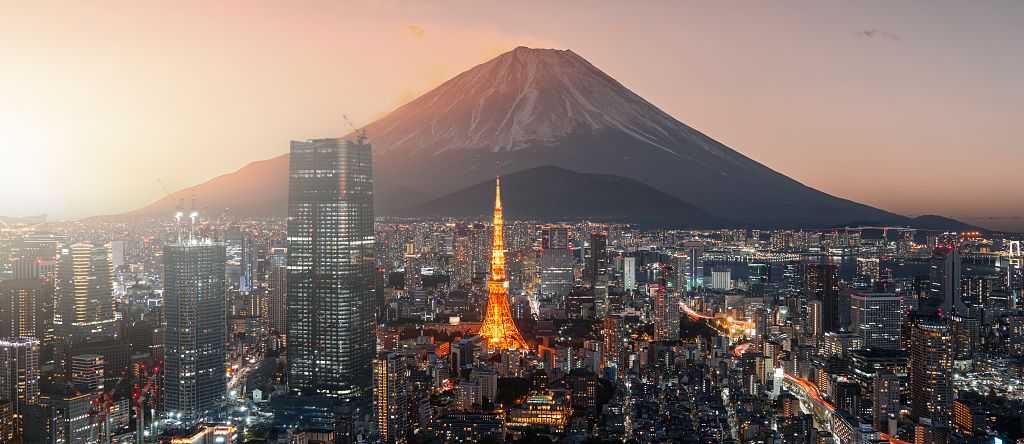 Tokyo, Japan The Tokyo skyline at sunset, featuring the silhouette of Mount Fuji behind the glowing orange frame of the Tokyo Tower.