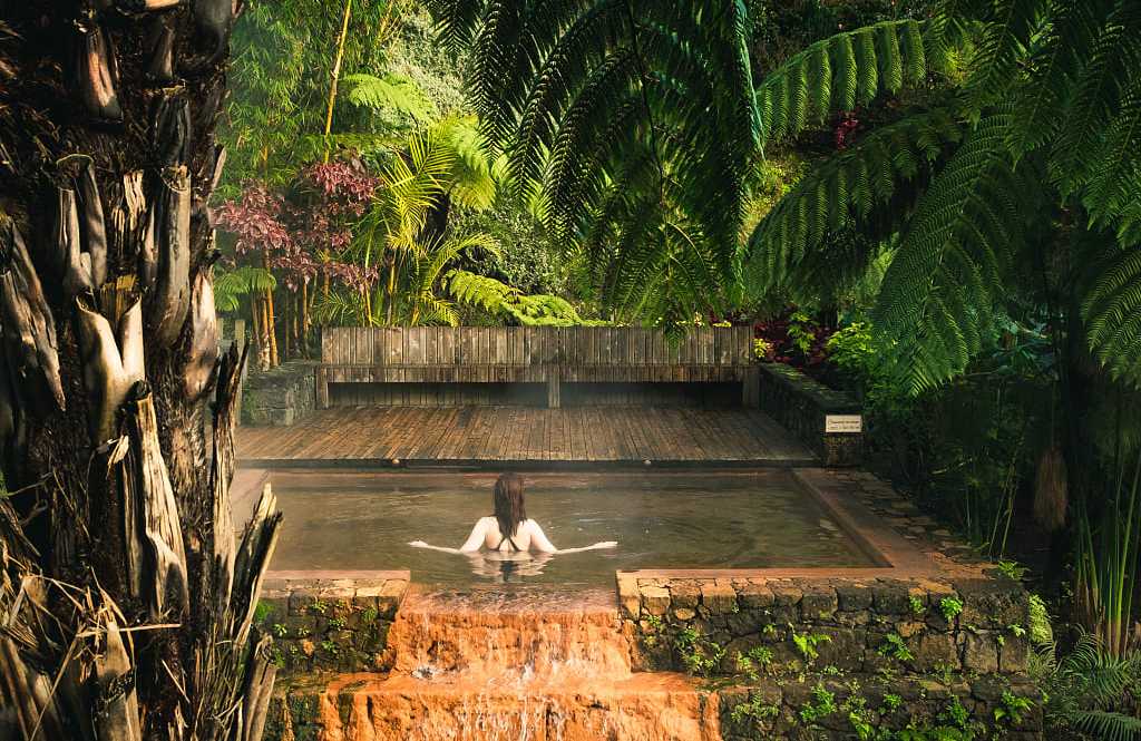 Poca da Dona Beija on Sāo Miguel, Azores Female tourist enjoying hot springs pool at Poca da Dona Beija on Sāo Miguel, Azores