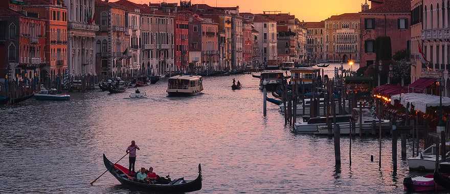 Couple taking sunset gondola ride on the Grand Canal in Venice, Italy