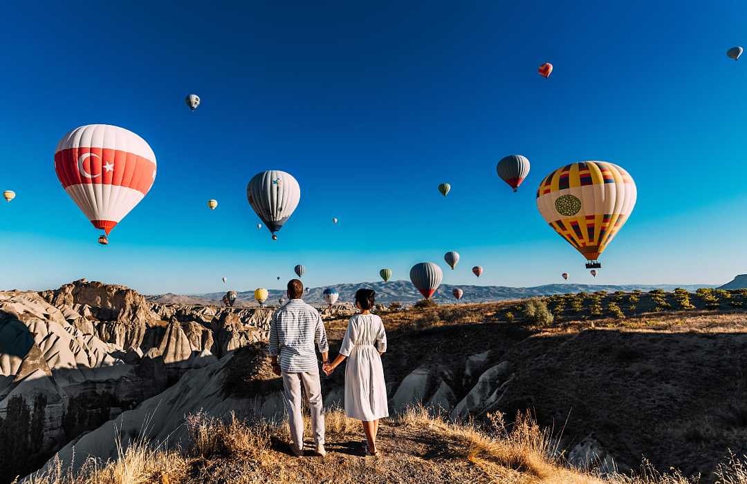 Couple watching the hot air balloons launch in Cappadocia, Turkey
