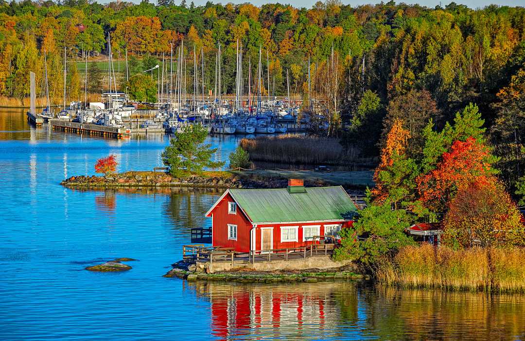 Red cabin and autumn forest on rocky shore of Ruissalo island, Turku Archipelago, Finland