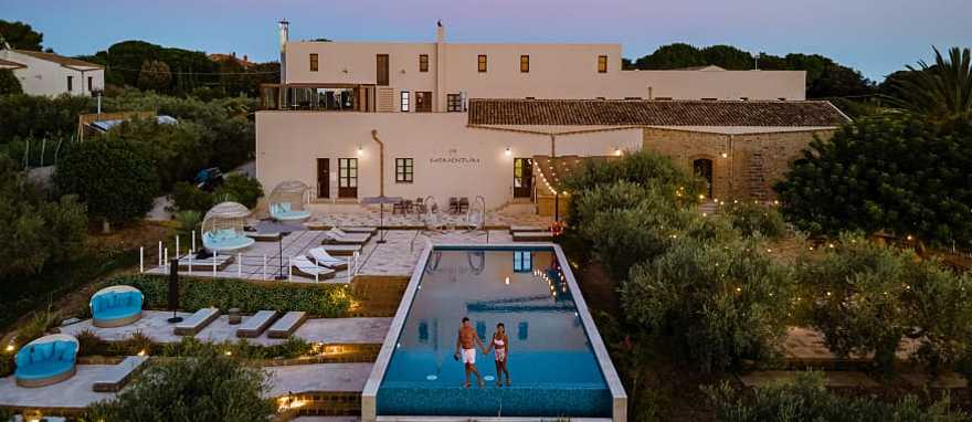 Couple at a luxury resort pool surrounded by vineyards in Selinunte, Sicily