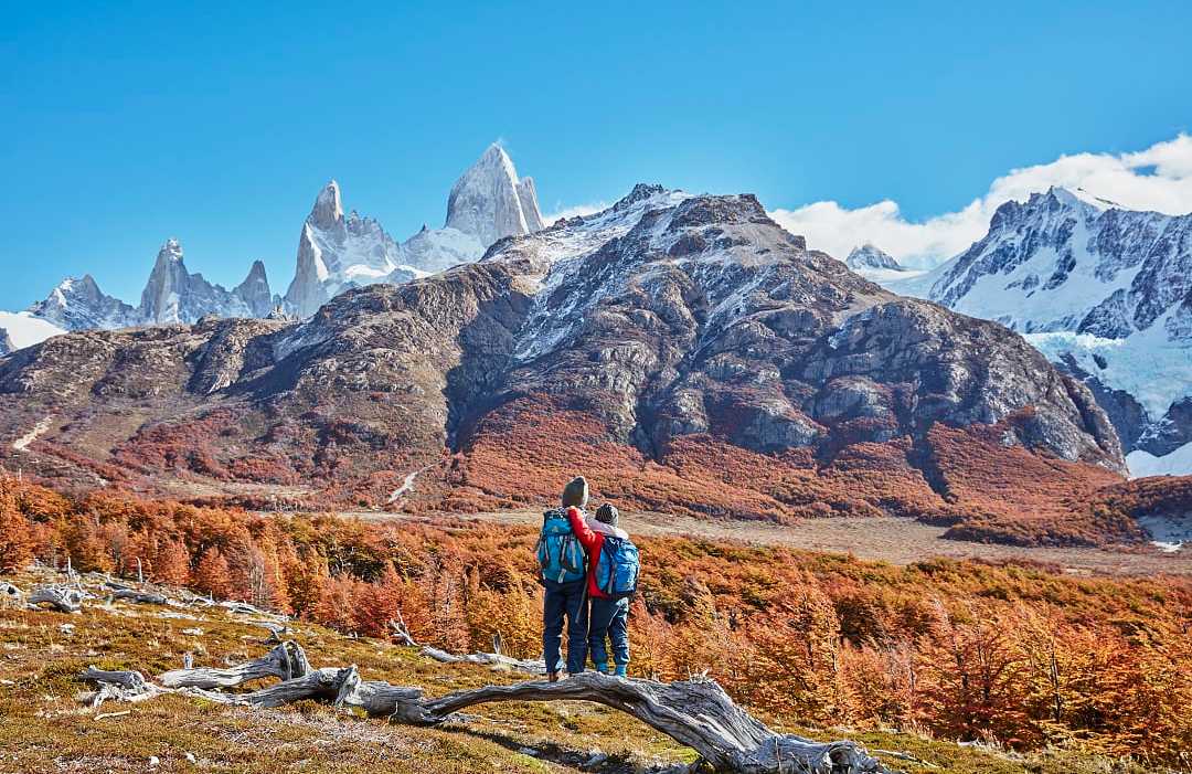 El Chaltén, Argentina Brothers admiring the snowy peaks of Mount Fitz Roy, Patagonia, Argentina, during autumn