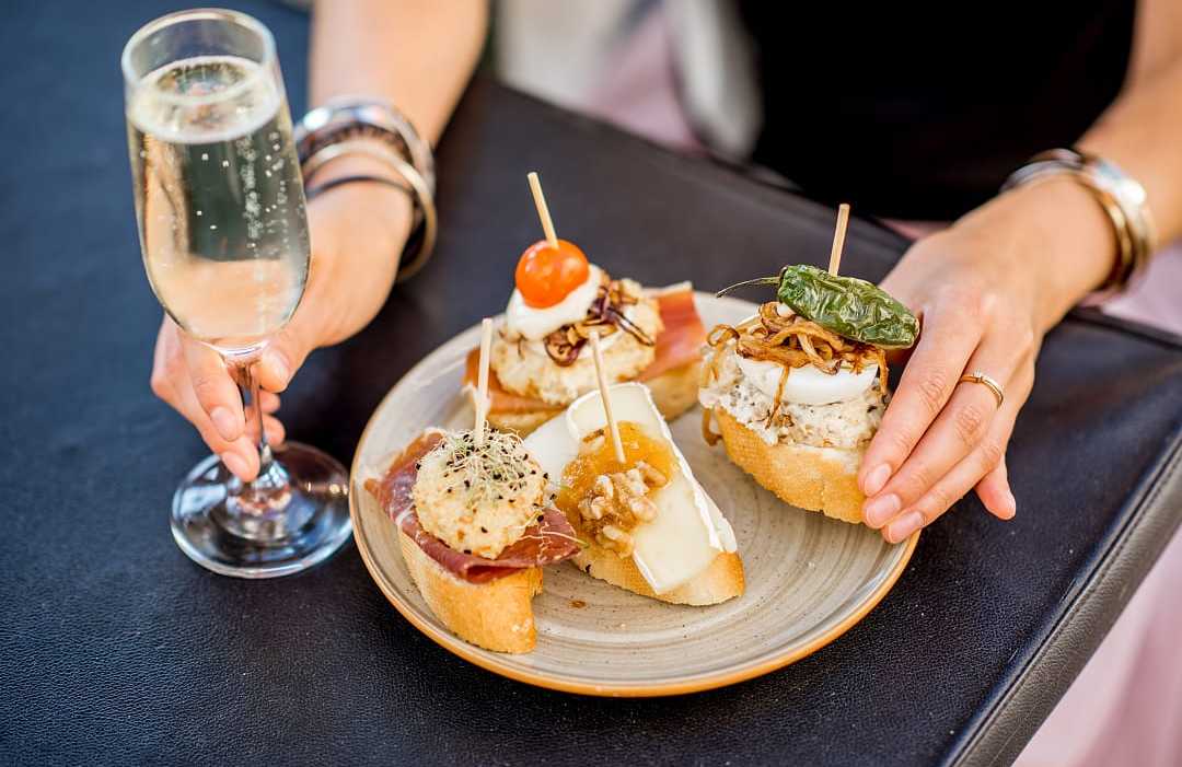 Plate of traditional Spanish pintxos with a glass of cava in San Sebastián, Spain