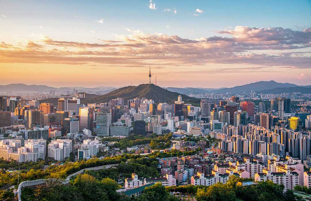 Panoramic view of Seoul city skyline with Namsan Seoul Tower at sunset.