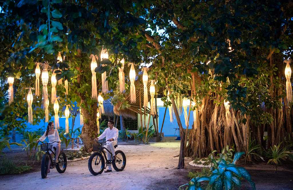 Couple fat biking around Fasmedhoo Island in the Maldives