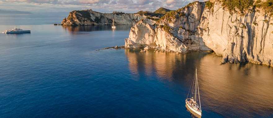 Sailboats at sunset around the beautiful island of Ponza in Italy