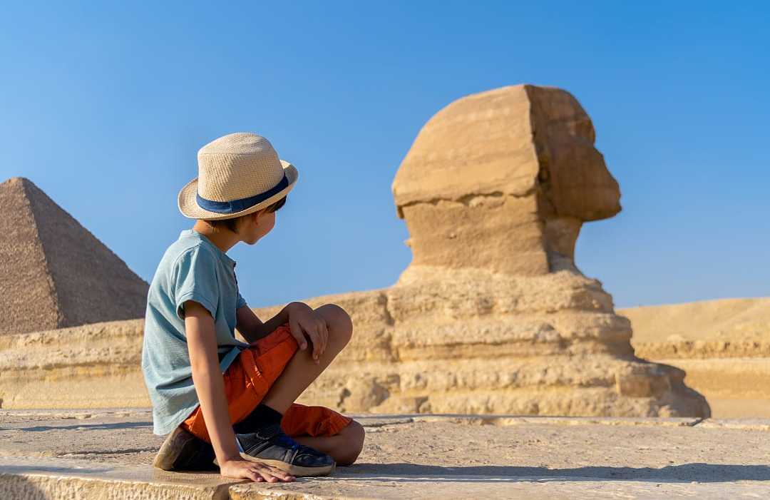 Giza, Egypt Young boy looking at the Great Sphinx of Giza in Egypt