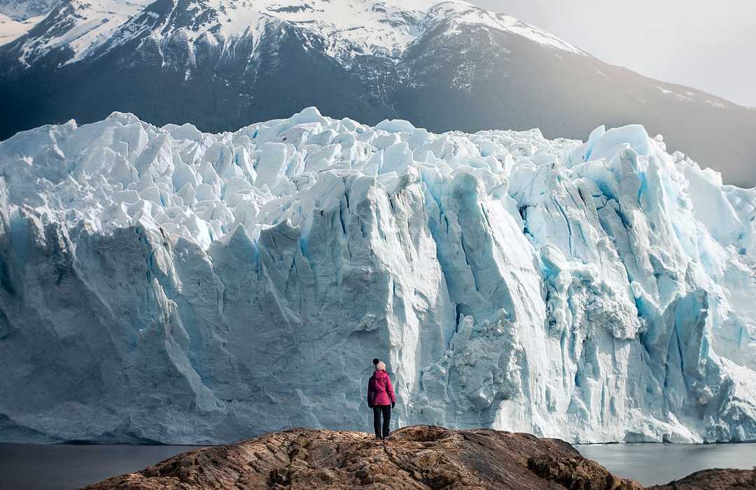 Woman standing in front of Perito Moreno Glacier in Argentina
