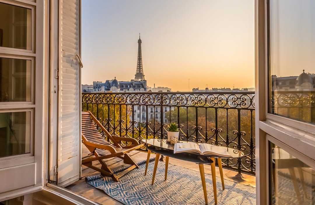 Stunning view of the Eiffel Tower at sunset, from a Parisian balcony.