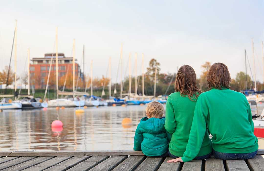 Family sitting on pier in Stockholm, Sweden.