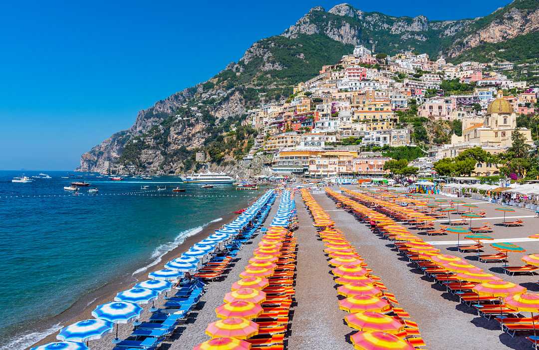 Orange and blue umbrellas on the beach in Positano on the Amalfi Coast of Italy