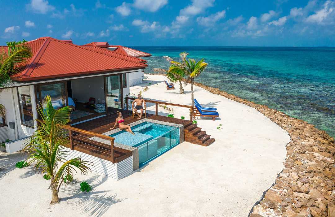 Photo courtesty of Ray Cay Private Island Resort Couple at a luxury beachfront villa with a private pool, ocean view, and palm trees in Belzie
