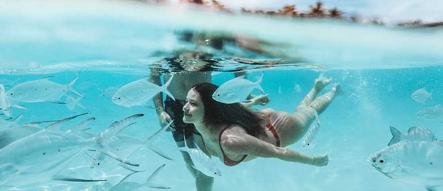 A couple swims in the ocean in the Maldives