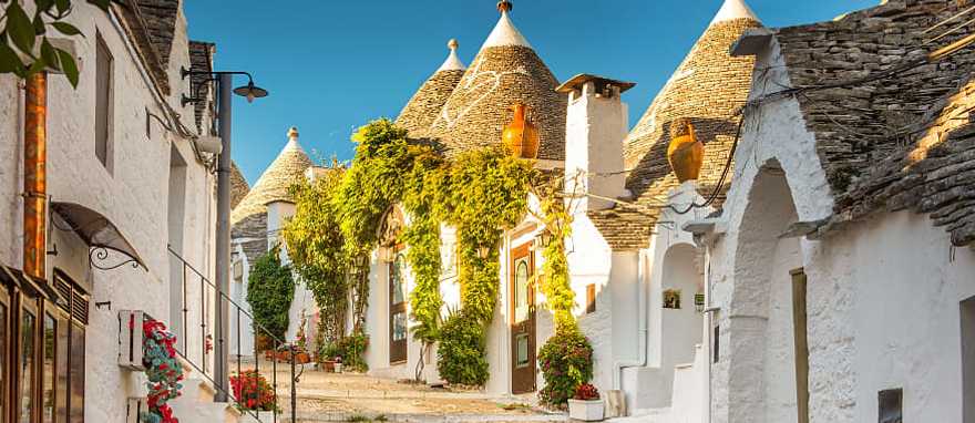 Trulli of Alberobello, Italy The cobblestone walkaway through the fairytale white limestone Trulli dwellings of Alberobello, Italy
