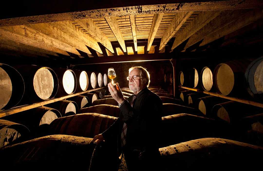 Worker testing whisky in distillery